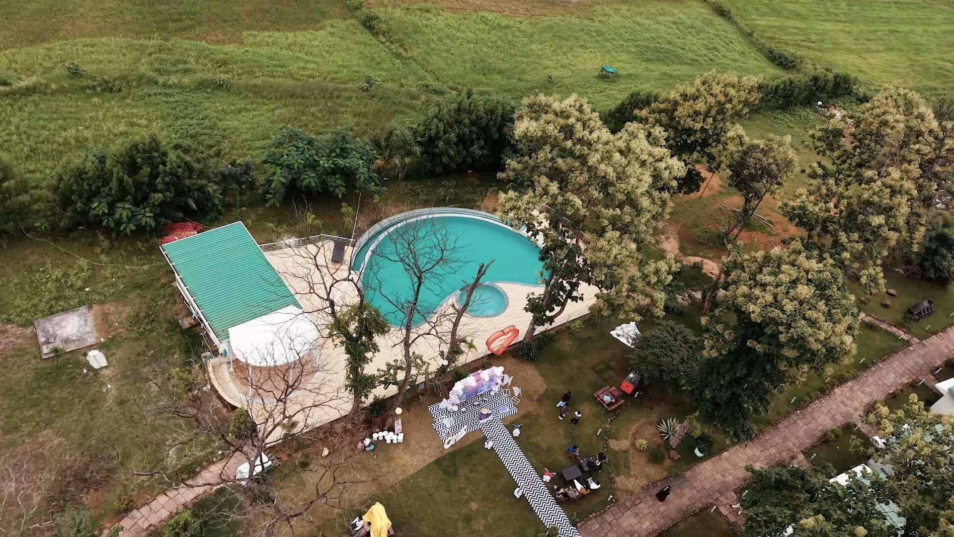 Aerial view looking down on the swimming pool and deck among trees
