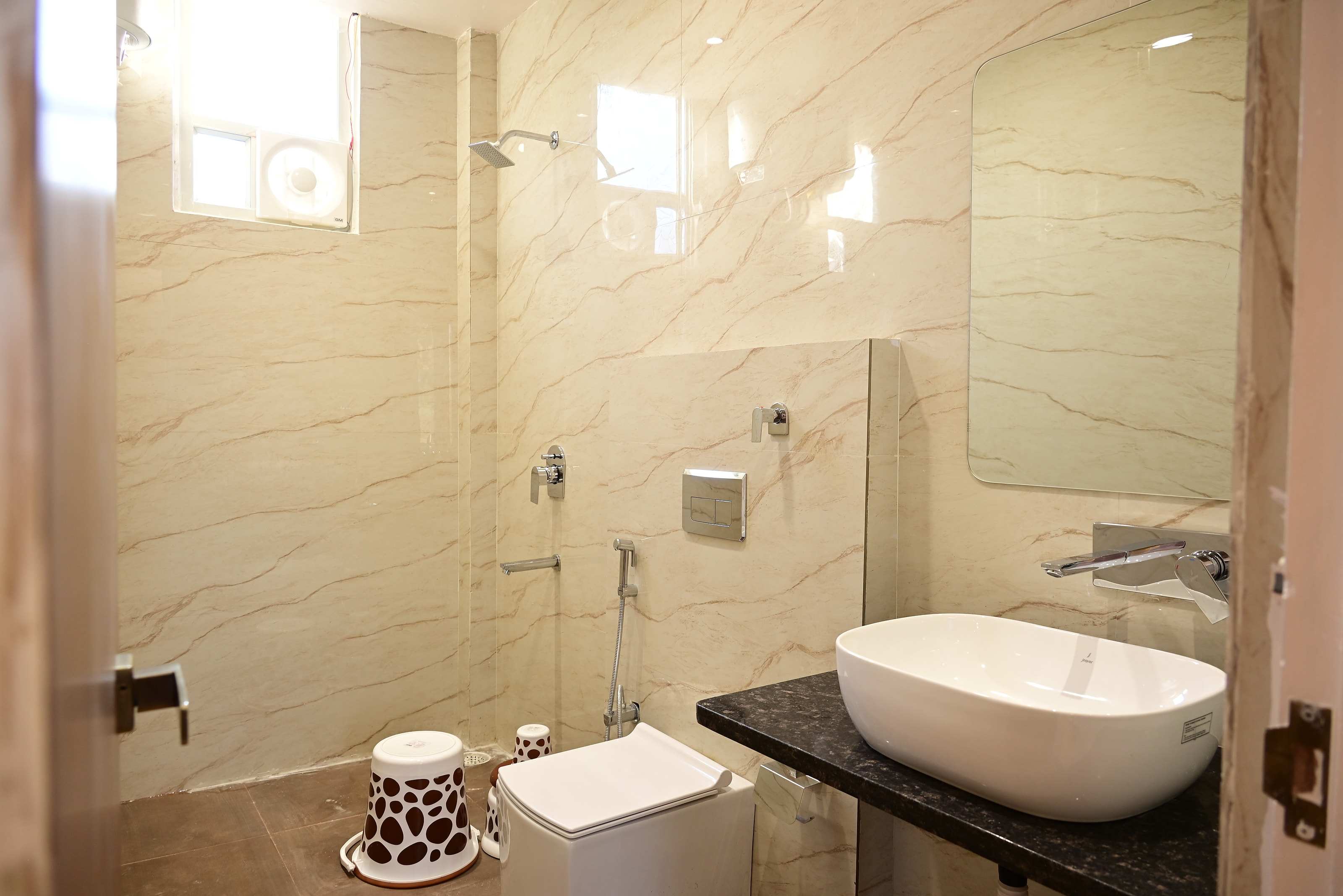Cottage bathroom with marble-look walls, a glass-screened shower, countertop basin and mirror