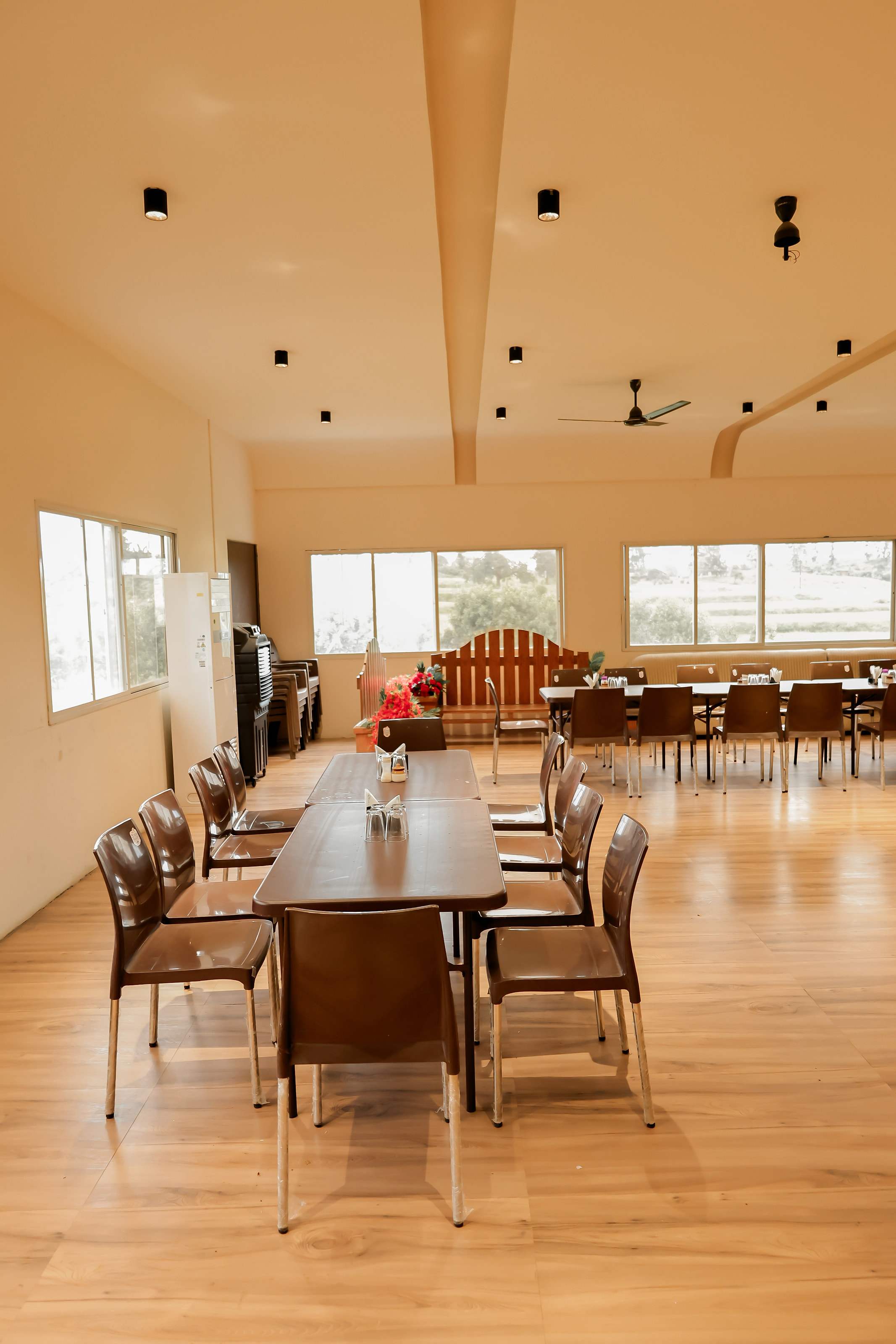 Long dining table set in the bright dining hall with wooden floors