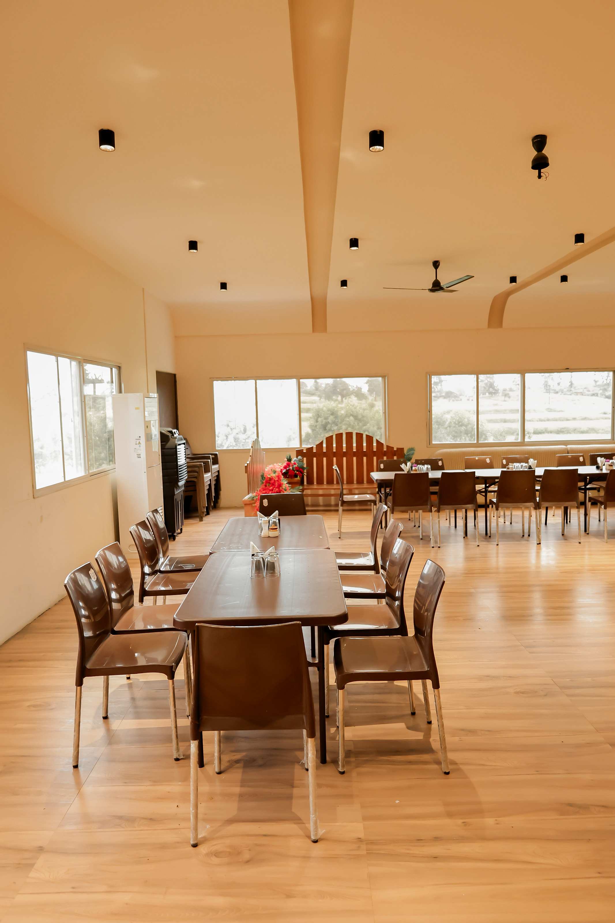 Long dining table set in the bright dining hall with wooden floors