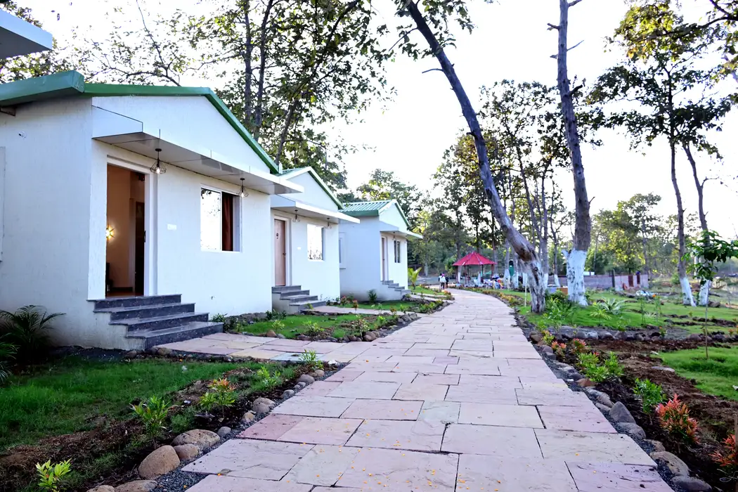 Row of white cottages with green roofs along a stone pathway