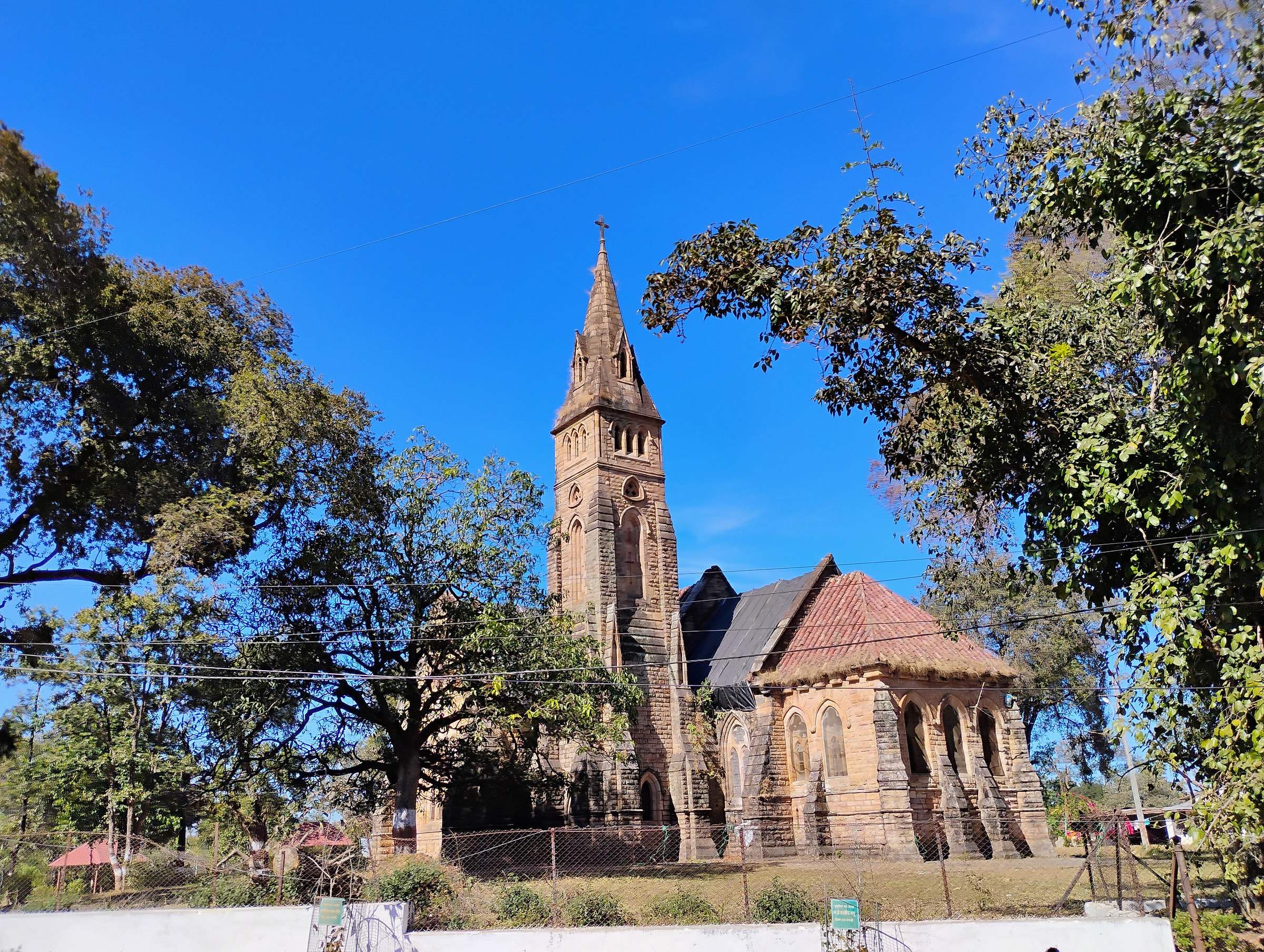 Christ Church, the stone church of Pachmarhi with its tall spire, under a blue sky