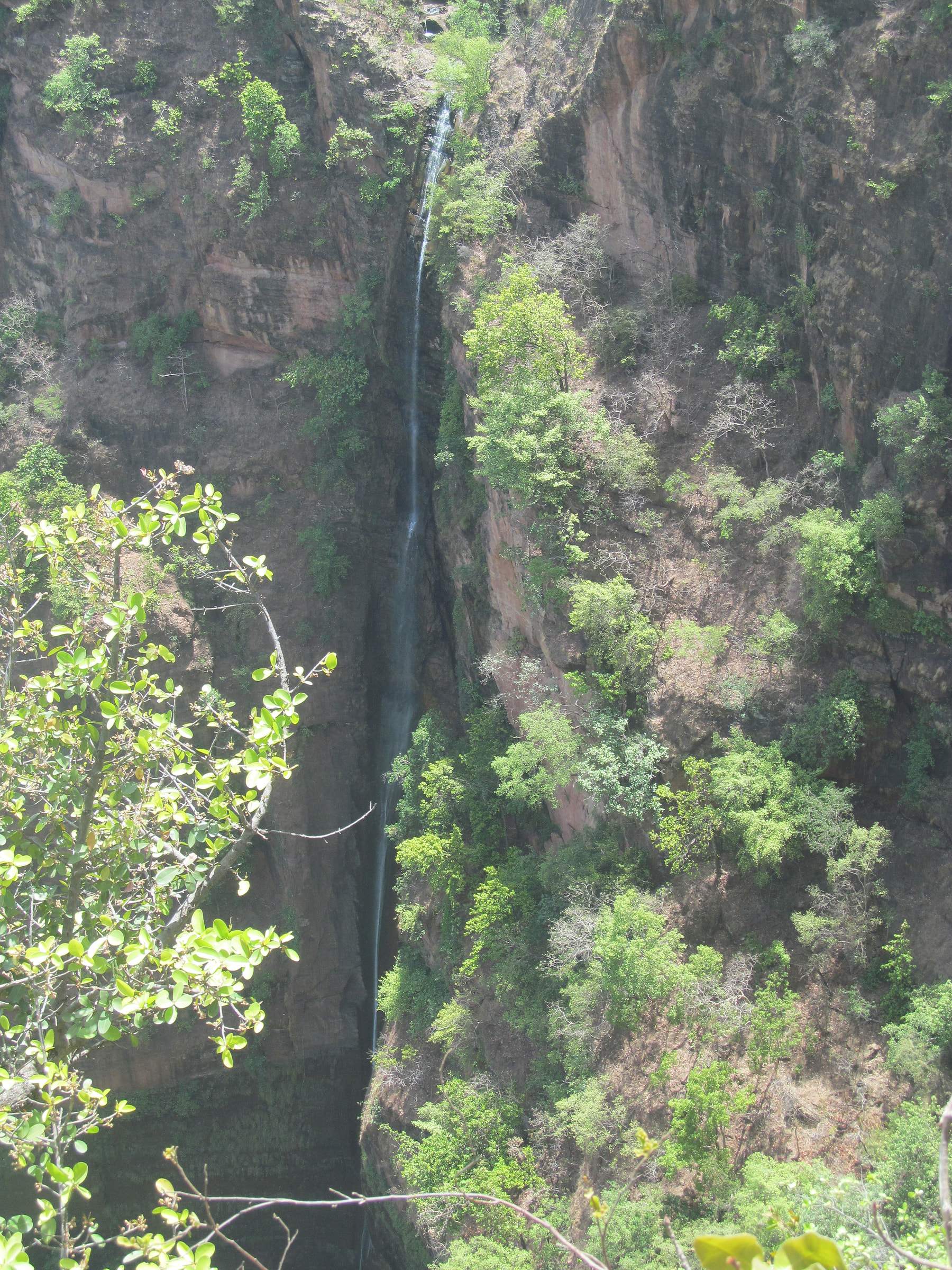 Rajat Prapat, a thin silver waterfall dropping down a forested cliff