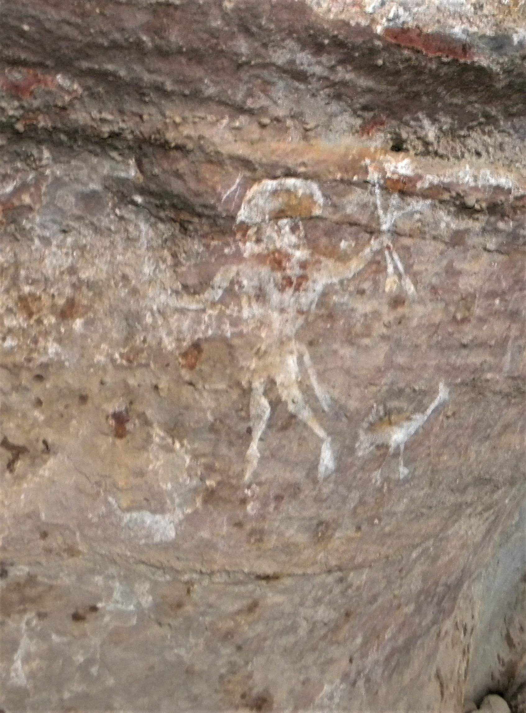 An ancient rock painting of a figure on a sandstone wall near Pachmarhi