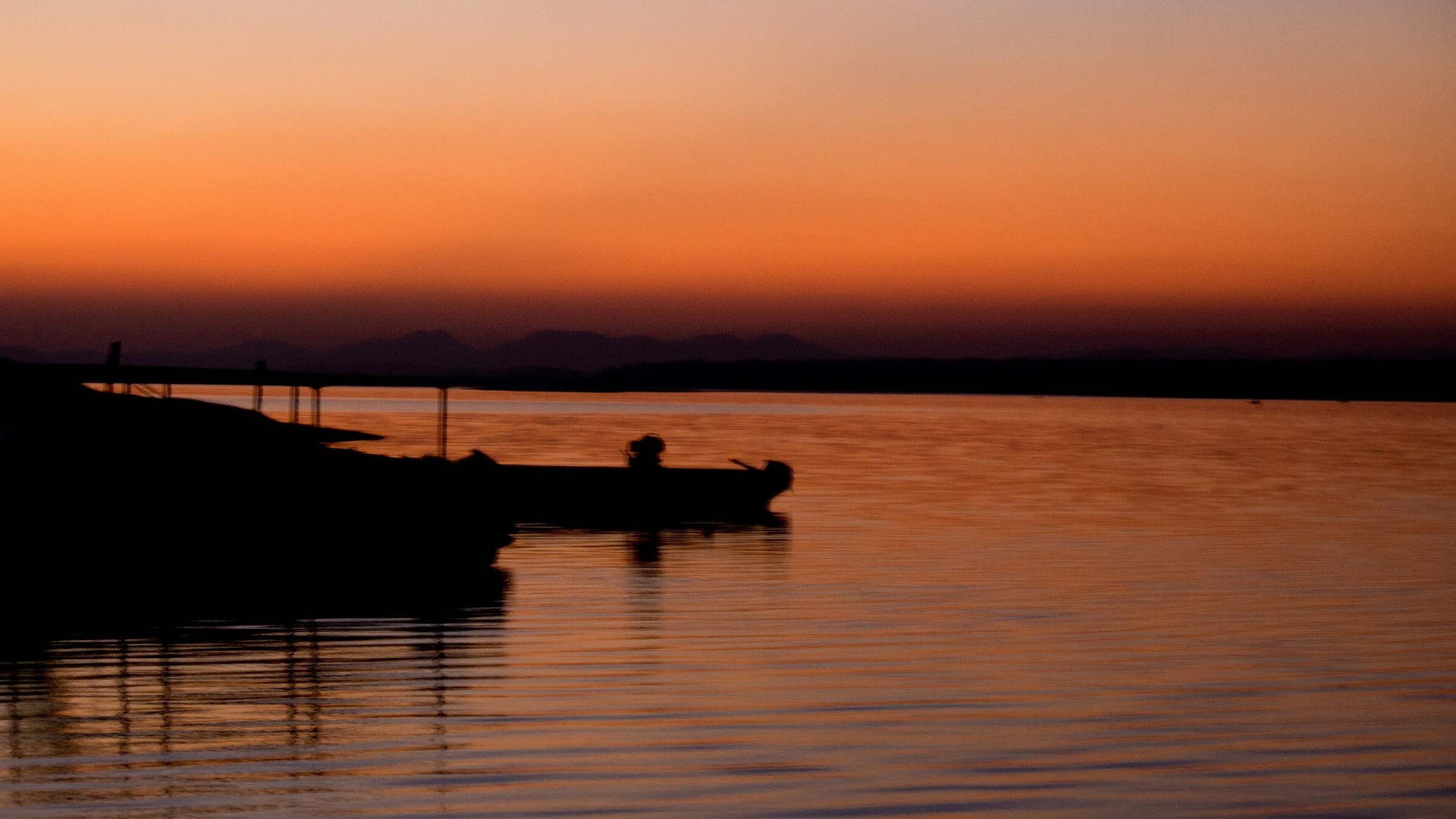A boat silhouetted on the Denwa at dusk in Satpura Tiger Reserve